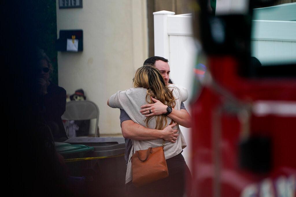 Two people at the scene of a plane crash in a neighborhood in Santee, Calif