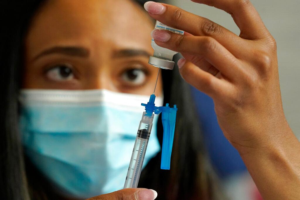 Nurse draws Moderna vaccine into a syringe 