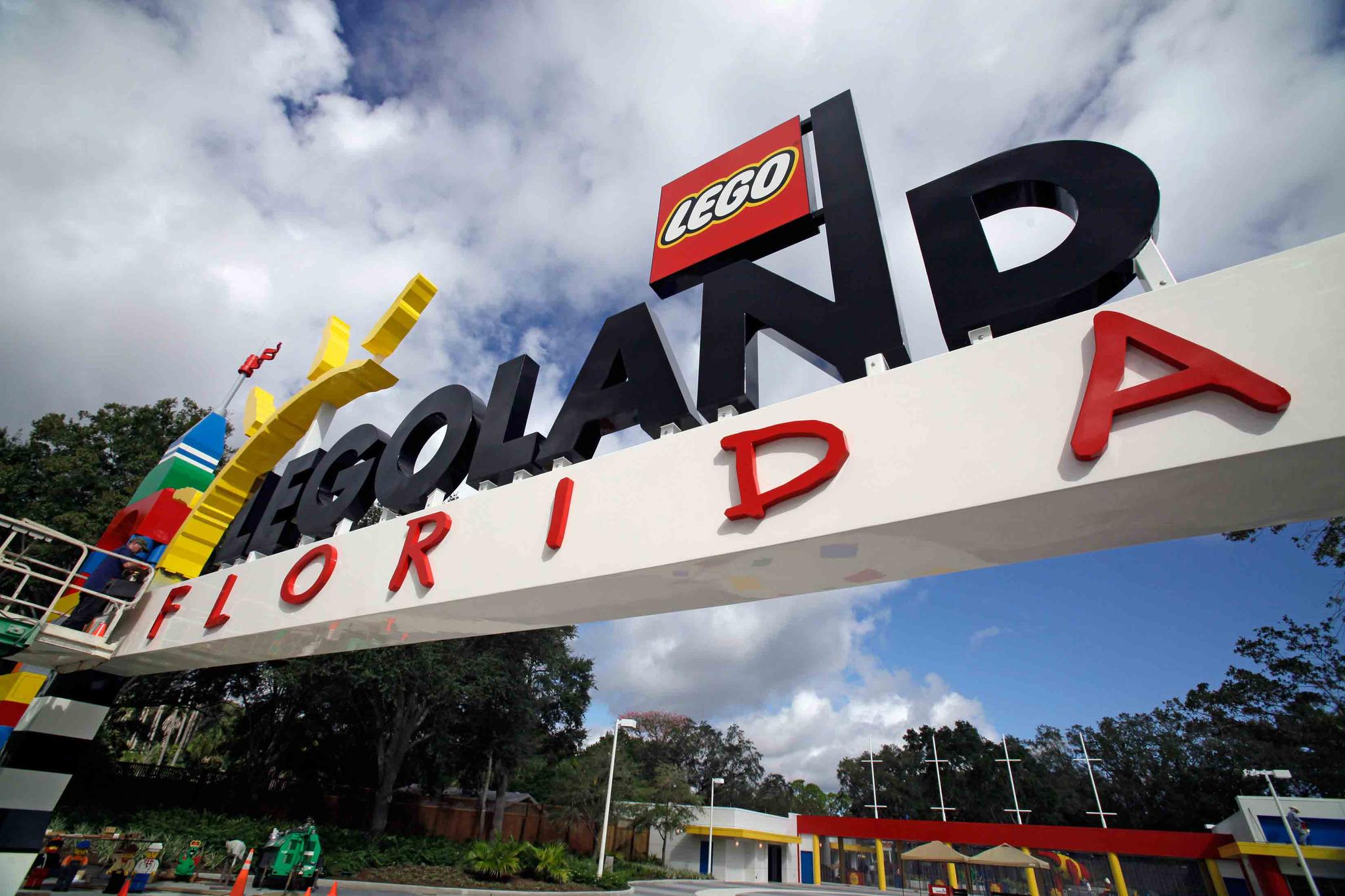 Tuesday, Sept. 27, 2011, file photo, a worker puts finishing touches on the entrance sign at Legoland Florida in Winter Haven, Fla.