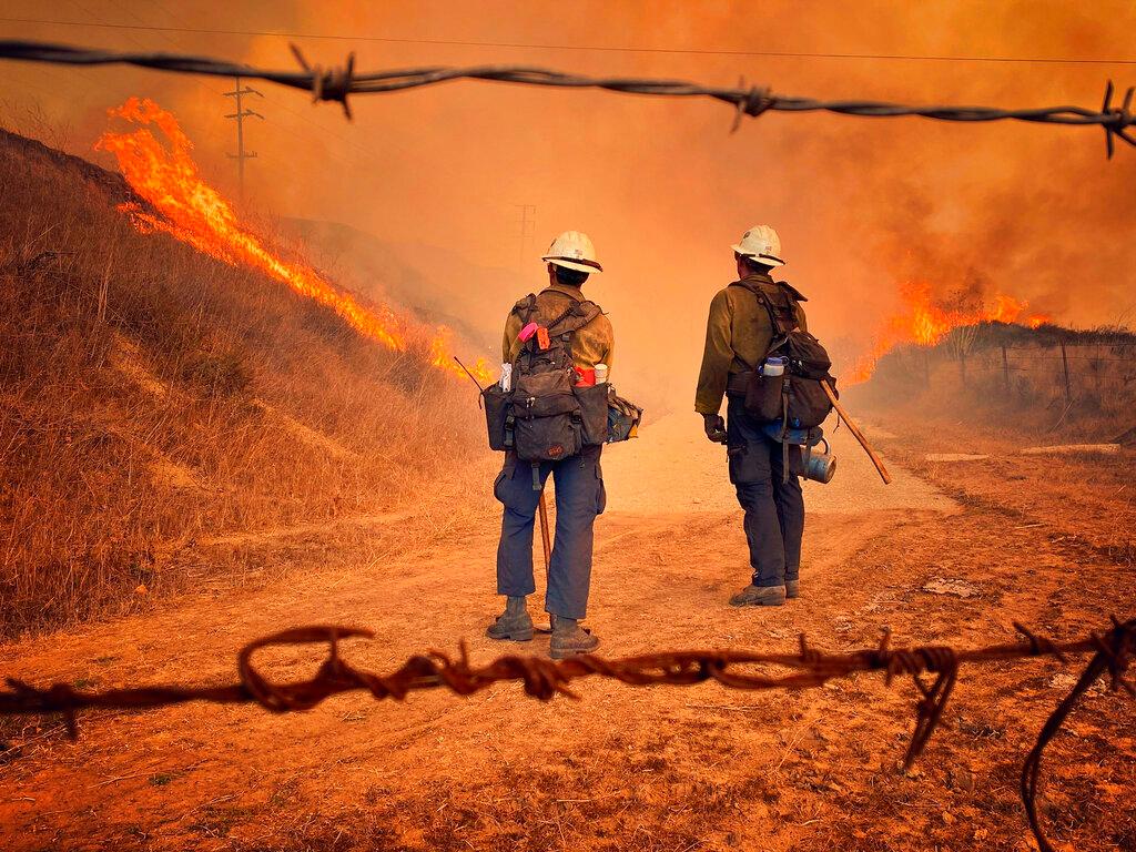 Santa Barbara County Fire Hand Crew members fight fire with fire and burn off pockets of grass along northbound Highway 101 north of Arroyo Hondo Canyon