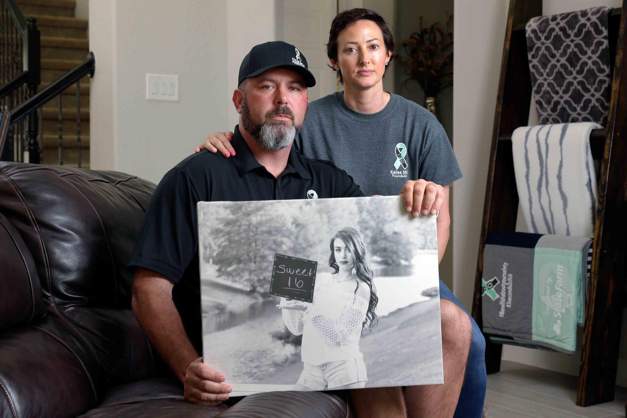 In this Oct. 12, 2021, photo, David and Wendy Mills, parents of Kailee Mills who was killed four years ago in an automobile accident when riding in the back seat without a seat belt, with a photo of their daughter at their home in Spring, Texas.