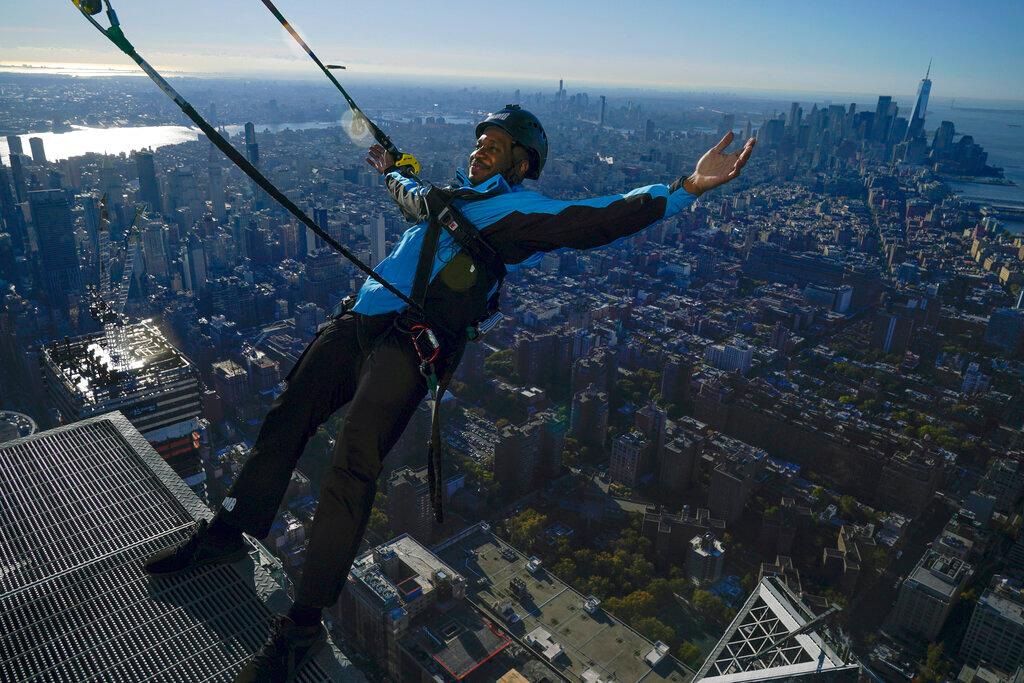 Climb guide Jason Johnson leans off the edge at the top of City Climb in New York 