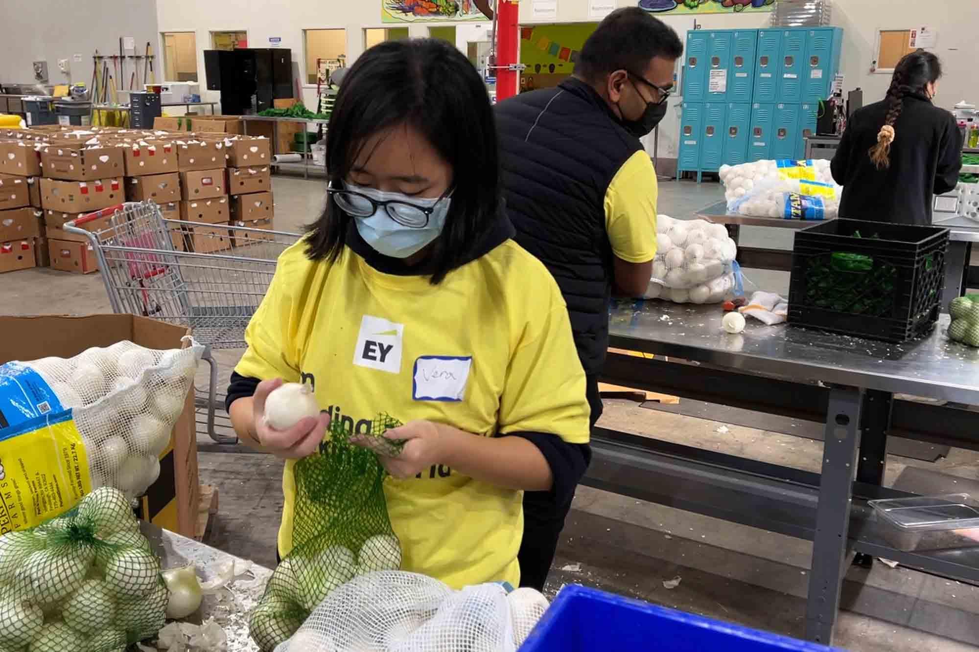 A volunteer packs onions in the warehouse of the Alameda County Community Food Bank in Oakland, Calif., on Nov. 5, 2021. U.S.