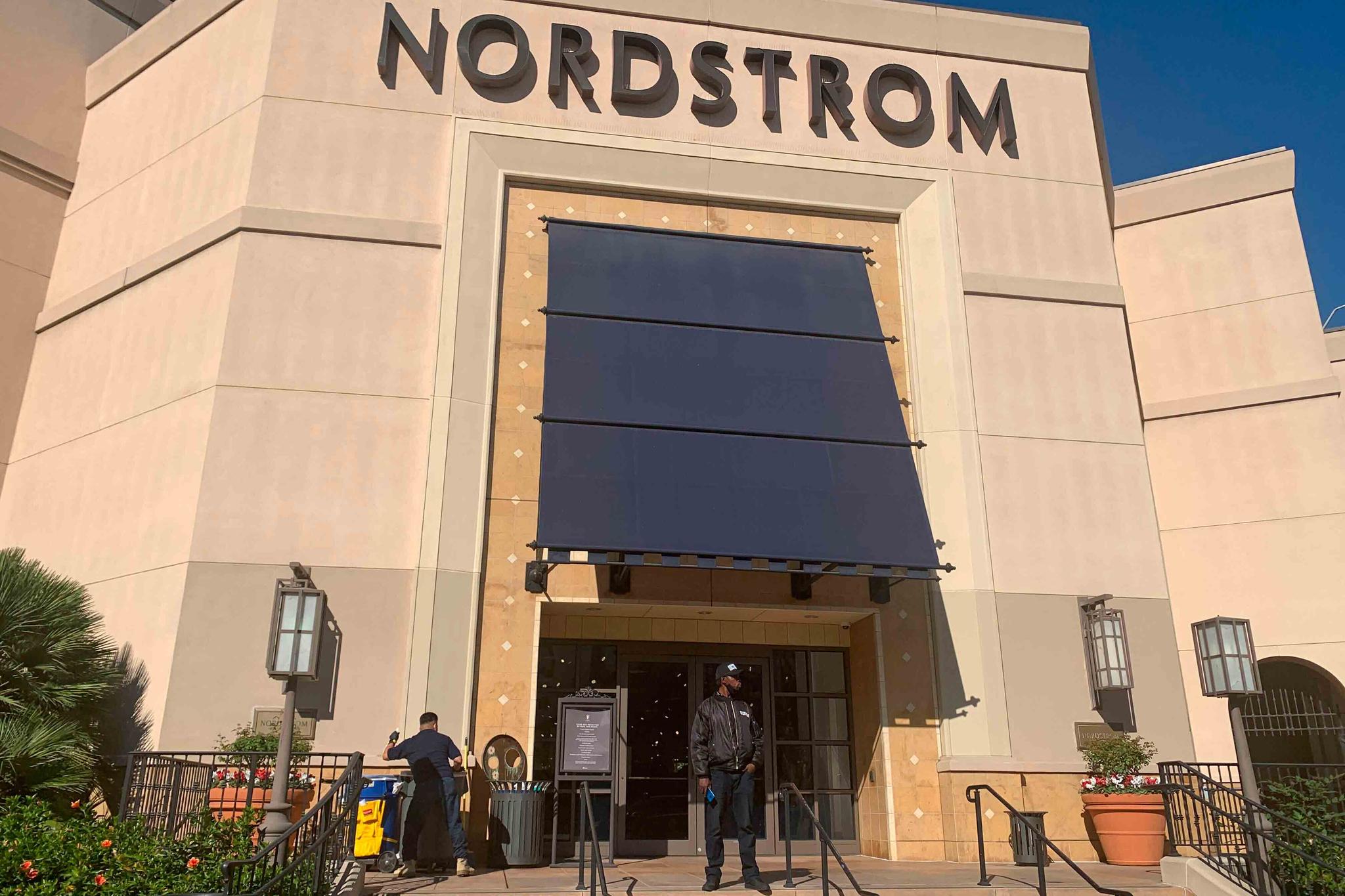 A security guard stands outside the Nordstrom store at The Grove retail and entertainment complex in Los Angeles, Tuesday, Nov. 23, 2021.
