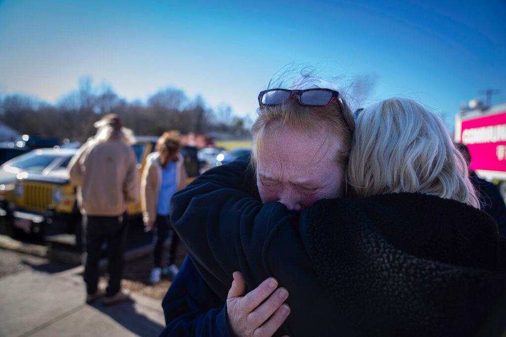 Tamara Yekinni hugs a friend outside a shelter in Wingo, Ky., on Sunday, Dec. 12, 2021, after residents were displaced by a tornado that caused severe damage in the area