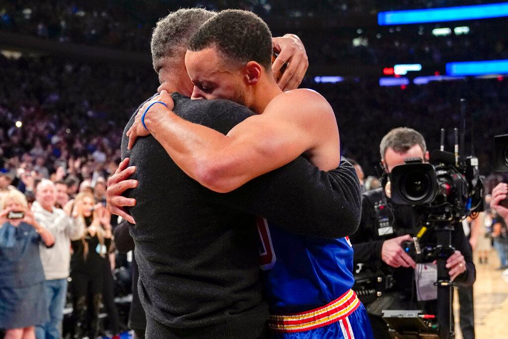 Stephen Curry hugs dad Dell Curry after scoring a 3 point shot that set the record for most 3s by a single player 