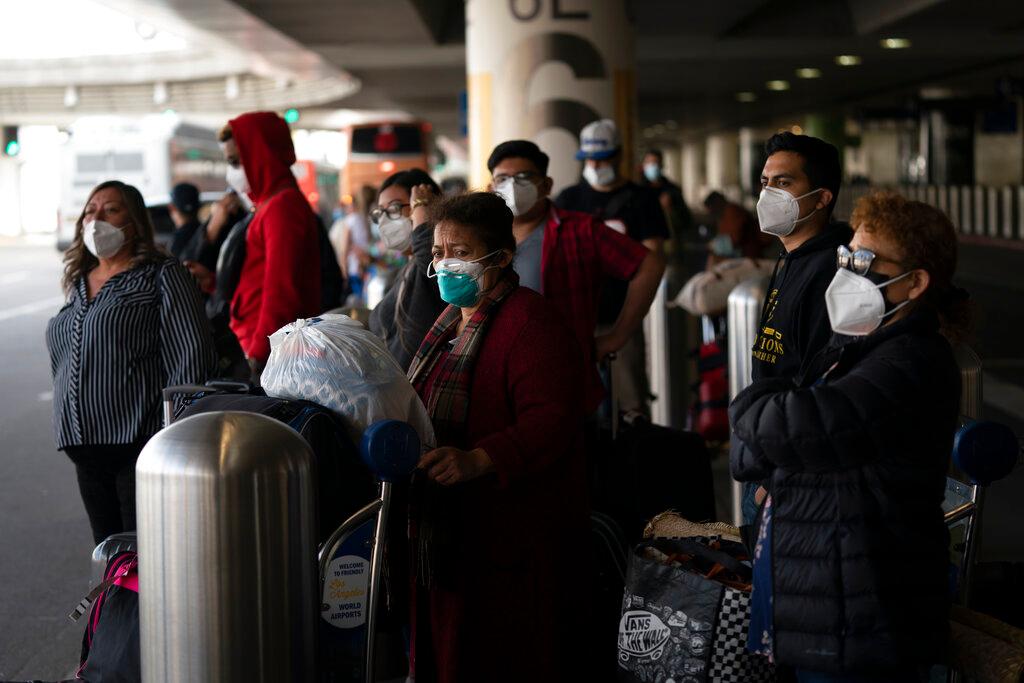 Travelers wait for a shuttle but to arrive at the Los Angeles International Airport in Los Angeles.