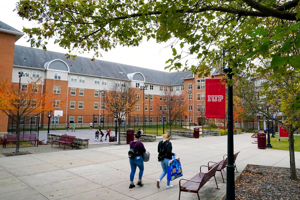 Students walk on the campus of Indiana University of Pennsylvania in Indiana, Pa., Oct. 21, 2020. The Biden administration on Wednesday, Dec. 22, 2021, extended a student loan moratorium that has allowed millions of Americans to put off debt payments during the pandemic. Under the action, payments on federal student loans will remain paused through May 1, 2022.