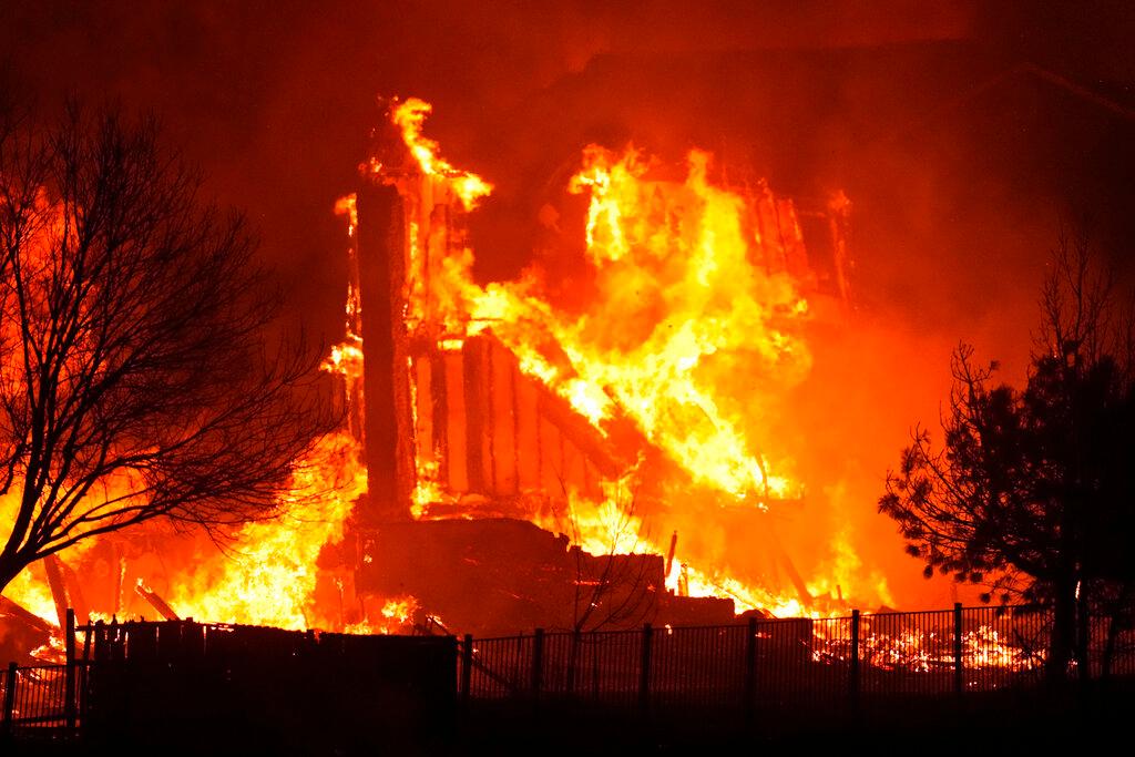Homes burn as a wildfire rips through a development near Rock Creek Village near Broomfield, Colo.