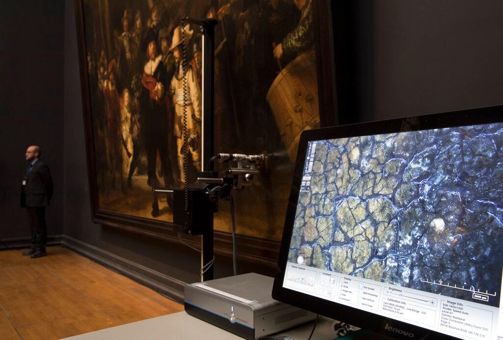  A microscopic image enlarging a 4x6 millimeter part of the painting on Rembrandt's Night Watch, which will be restored next year in the public eye, is seen on a screen next to the painting at the Rijksmuseum in Amsterdam, Netherlands