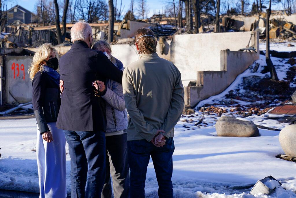 President Joe Biden and first lady Jill Biden talk with people as they tour a neighborhood in Louisville, Colo.,