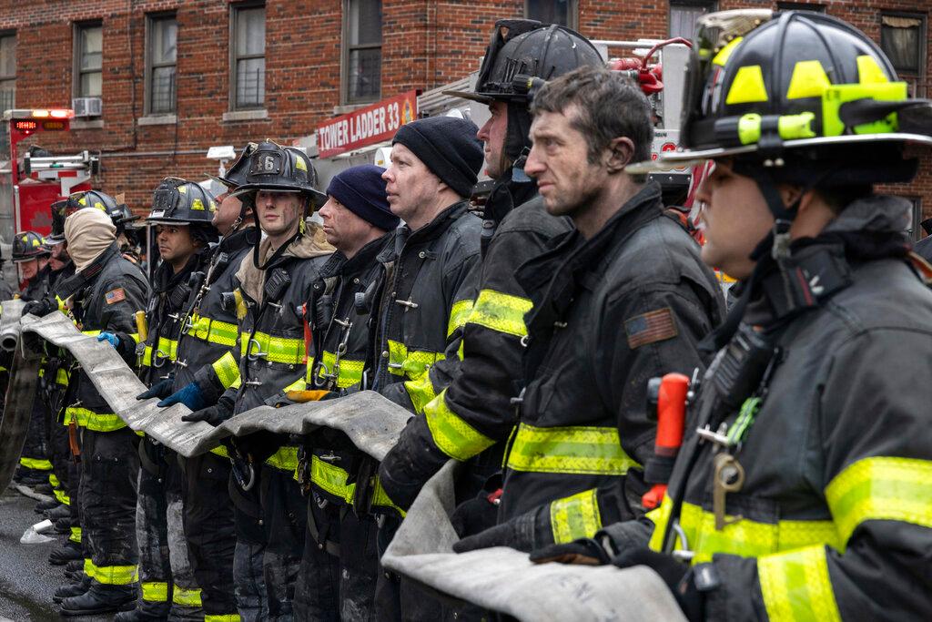 Firefighters work at the scene of a fatal fire at an apartment building in the Bronx 