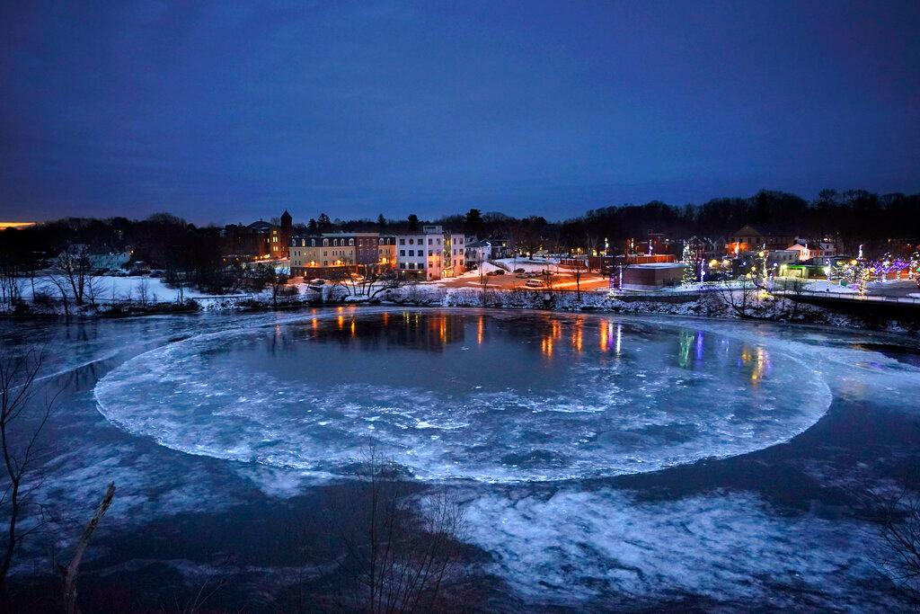 A large ice disk slowly rotates in the Presumpscot River 