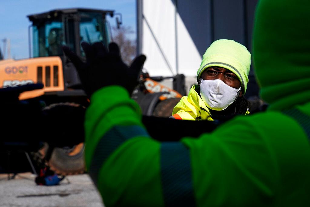 A man looks at a brine truck tank being filled ahead of a winter storm