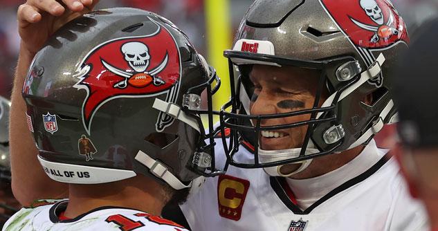 Two football players in helmets smiling