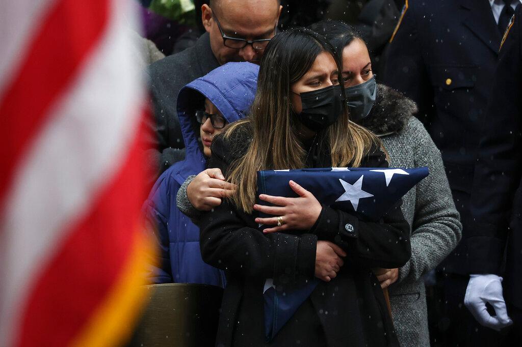 Dominique Rivera, left, wife of, NYPD Officer Jason Rivera watches as his casket is loaded into a hearse