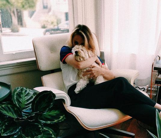 woman cuddles dog