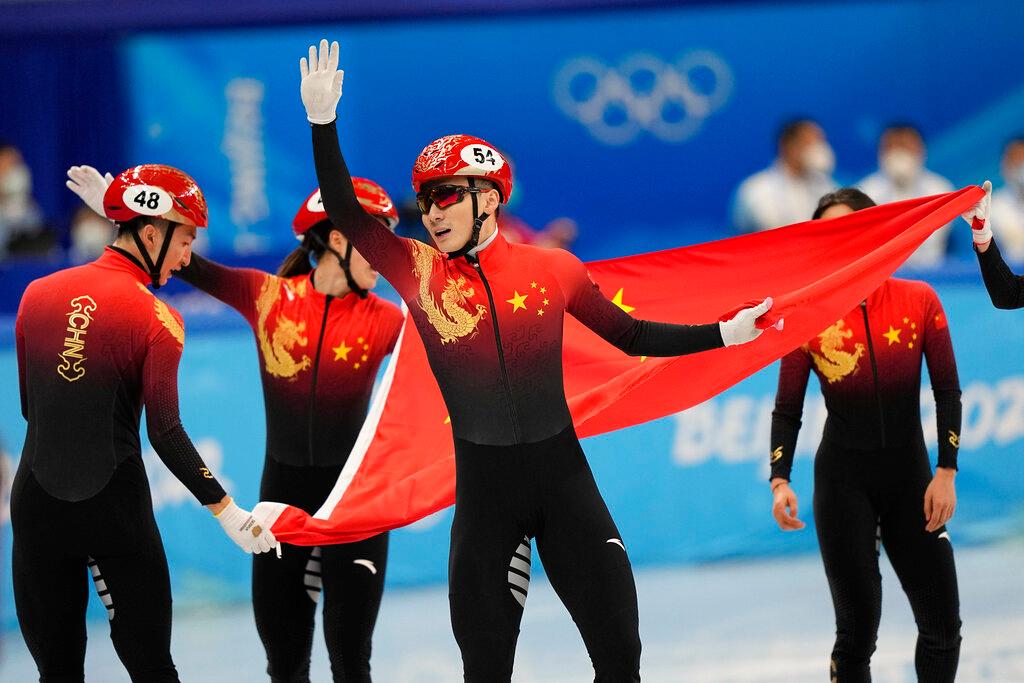 Ren Ziwei of China celebrates with teammates after they won the mixed team relay final during the short track speedskating competition at the 2022 Winter Olympics