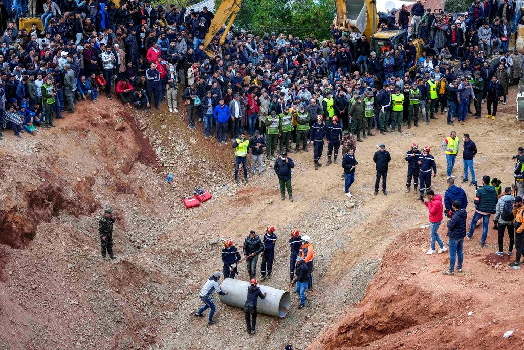 Rescue workers roll cylinders as they attempt to build a tunnel to rescue a 5-year-old boy who fell into a hole in the northern village of Ighran in Morocco's Chefchaouen province