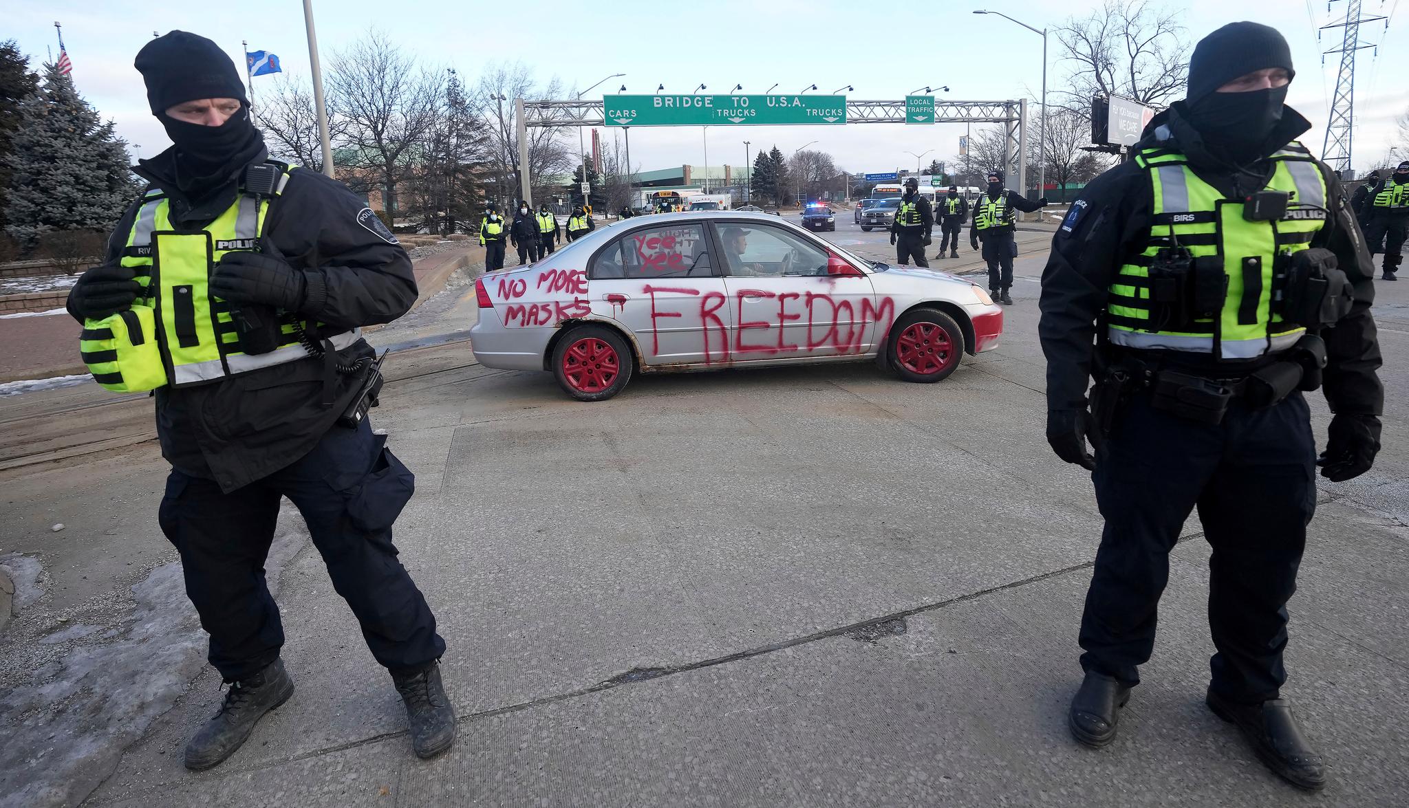 Police look on as a protest vehicle leaves a demonstration