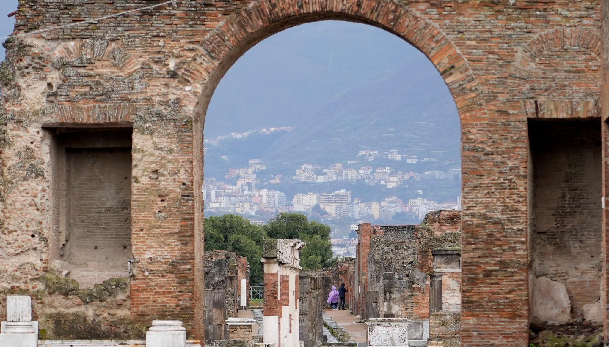 Tourists walk inside the Pompeii archaeological site