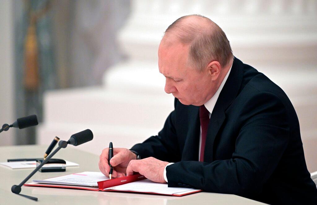 Russian President Vladimir Putin signs a document recognizing separatist regions in eastern Ukraine 