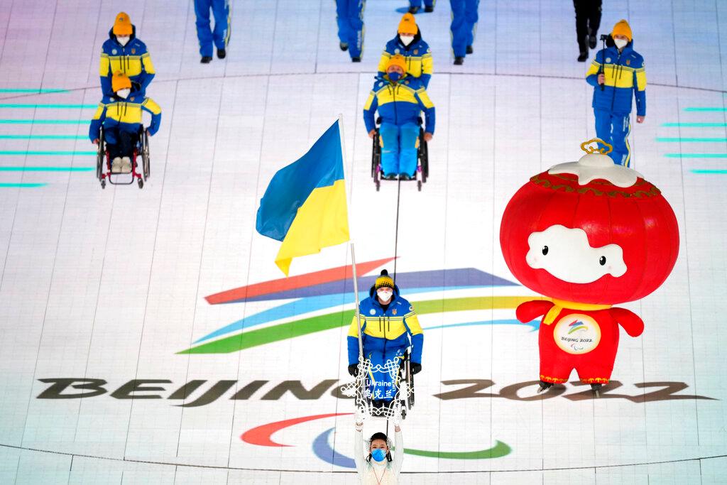 Maksym Yarovyi of Ukraine carries the flag as the team makes their entrance during the opening ceremony at the 2022 Winter Paralympics