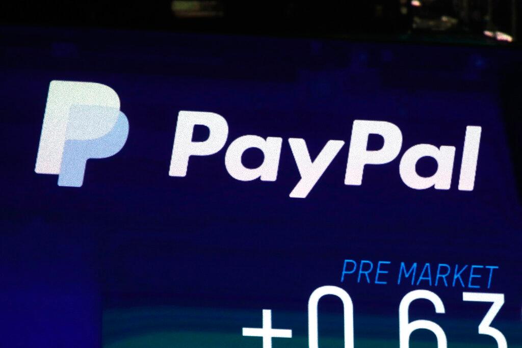 In this Oct. 3, 2018, file photo the PayPal logo appears on a screen at the Nasdaq MarketSite, in New York's Times Square. PayPal says that its users will now be able to send money to Ukrainians, both in the war-ravaged country as well as those who are now refugees across Europe, Thursday, March 17, 2022.
