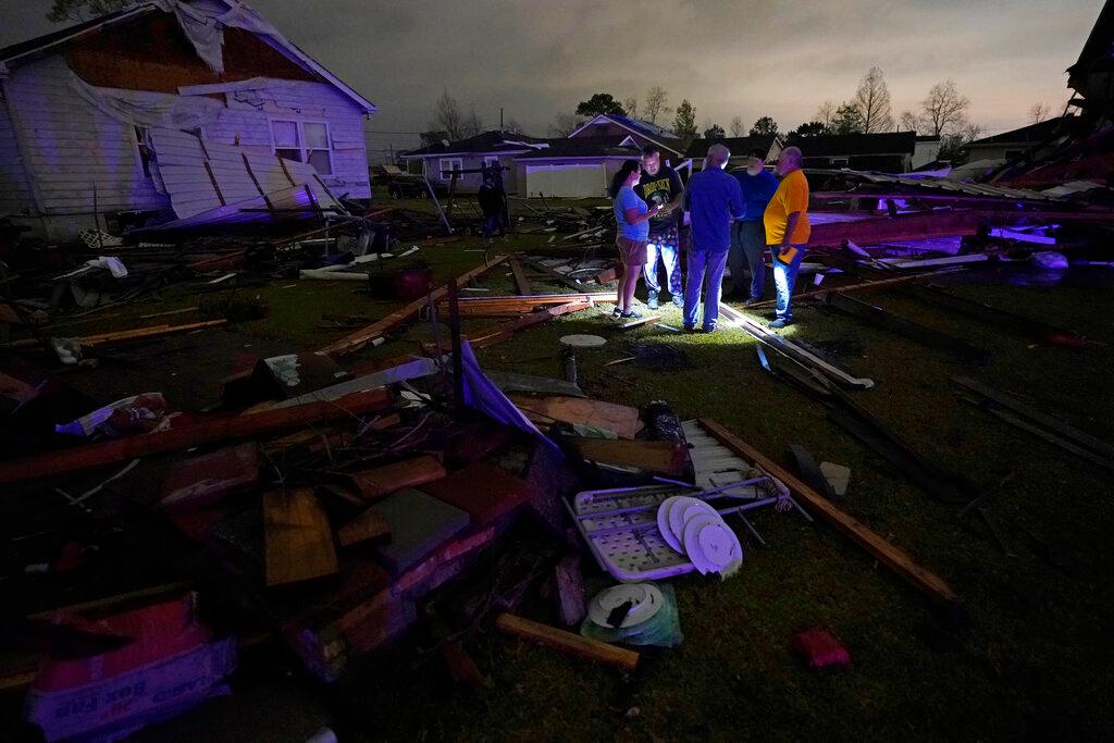 Neighbors talk amongst debris of their damaged homes near New Orleans 