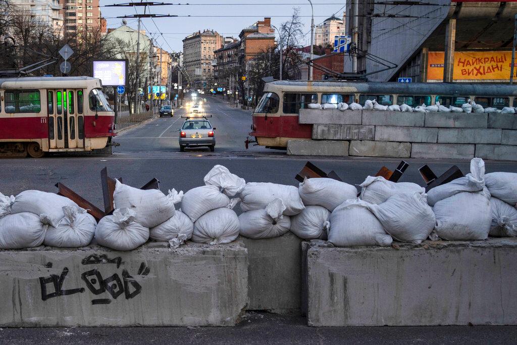 A driver passes through a barricade built by territorial defense units downtown in Kyiv 