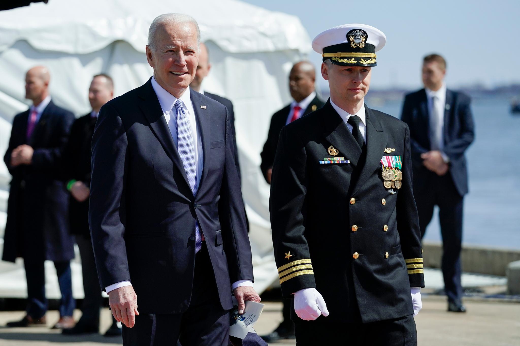 President Joe Biden is escorted by Cmdr. Matthew Horton, Commanding Officer, USS Delaware, as he arrive to attend a commissioning ceremony for USS Delaware, Virginia-class fast-attack submarine, at the Port of Wilmington in Wilmington, Del., Saturday, April 2, 2022.