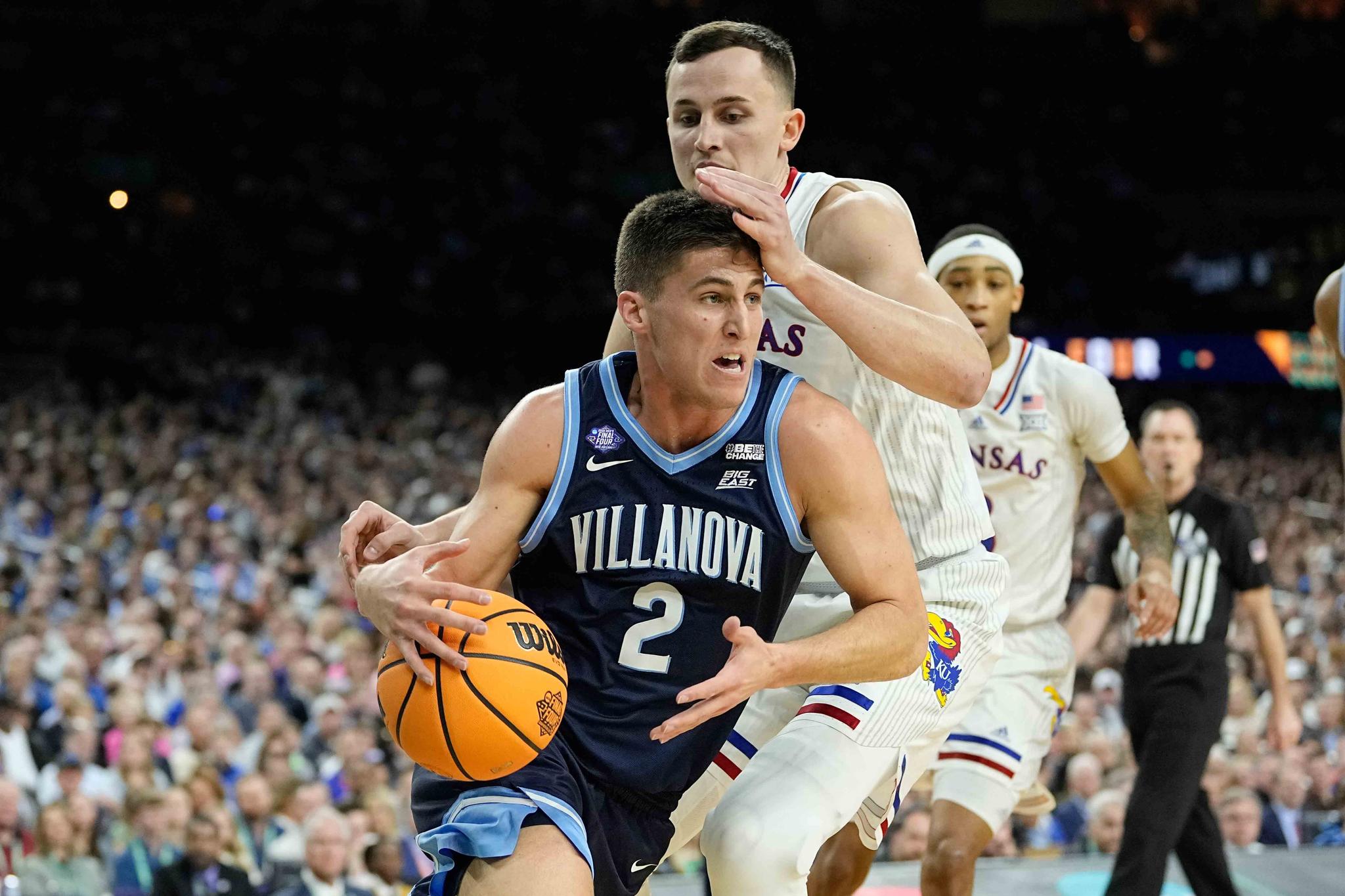 Villanova's Collin Gillespie (2) drives to the basket past Kansas forward Mitch Lightfoot during the first half of a college basketball game in the semifinal round of the Men's Final Four NCAA tournament, Saturday, April 2, 2022, in New Orleans.