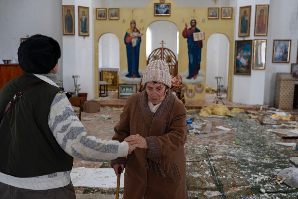 A woman reacts as she enters a damaged church following a Russian attack in the previous weeks in the town of Makarov