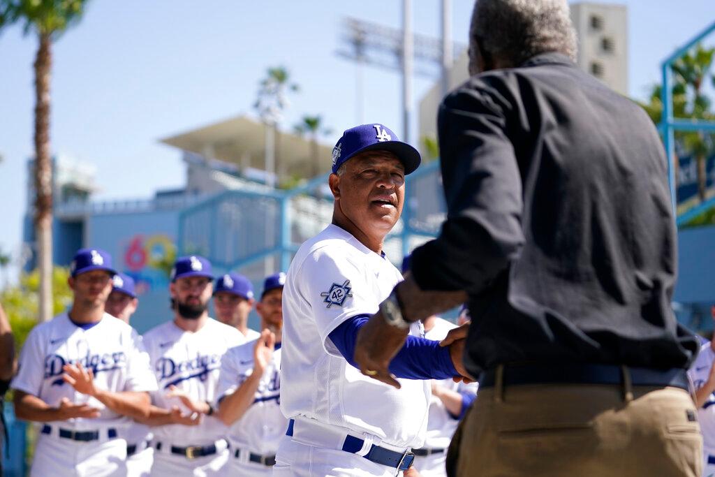Los Angeles Dodgers' manager Dave Roberts, center, shakes hands with David Robinson, son of Jackie Robinson, before a baseball game between the Cincinnati Reds and the Los Angeles Dodgers in Los Angeles, Friday, April 15, 2022. 