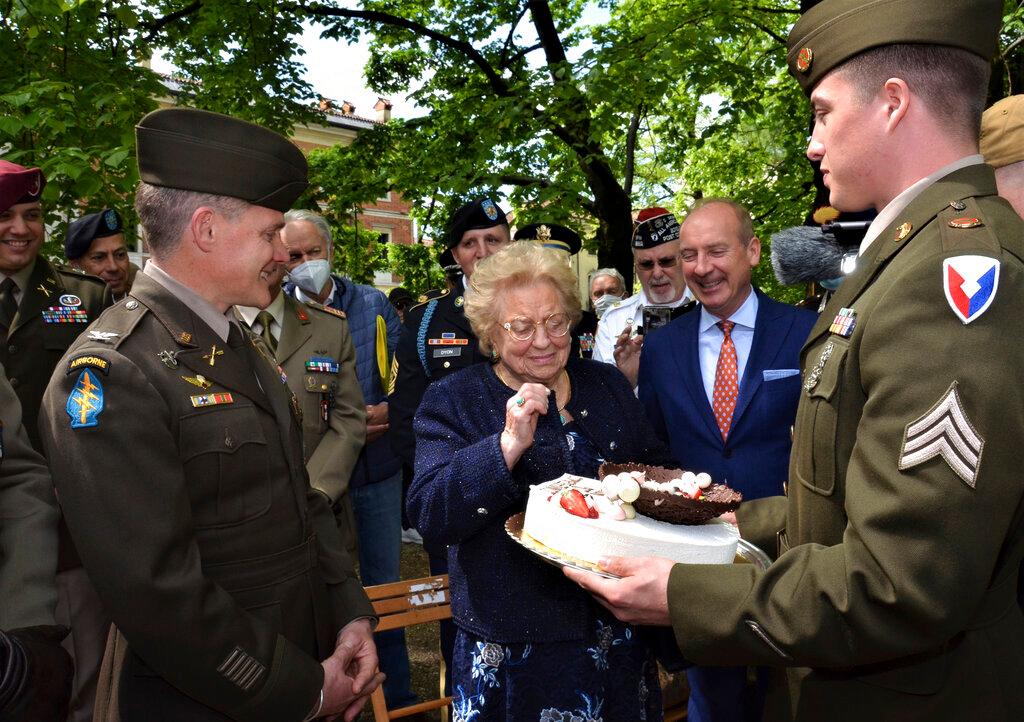 Soldiers from U.S. Army Garrison Italy return a birthday cake to Meri Mion, center, in Vicenza, northern Italy