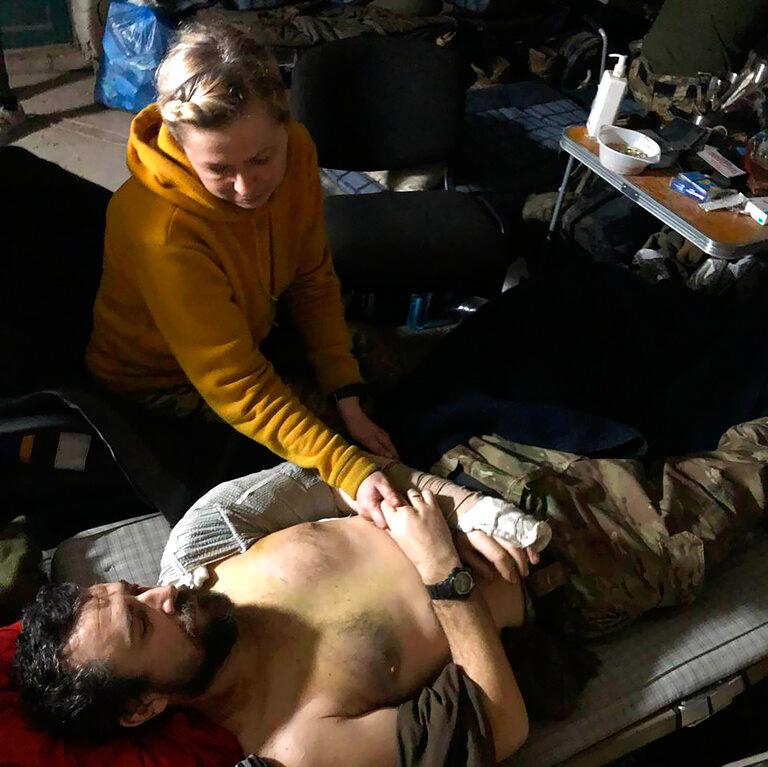 This recent but undated photo provided Friday, April 29, 2022 by the wife of a member of the Azov Regiment shows a woman comforting a wounded man inside the Azovstal steel plant, in Mariupol, eastern Ukraine
