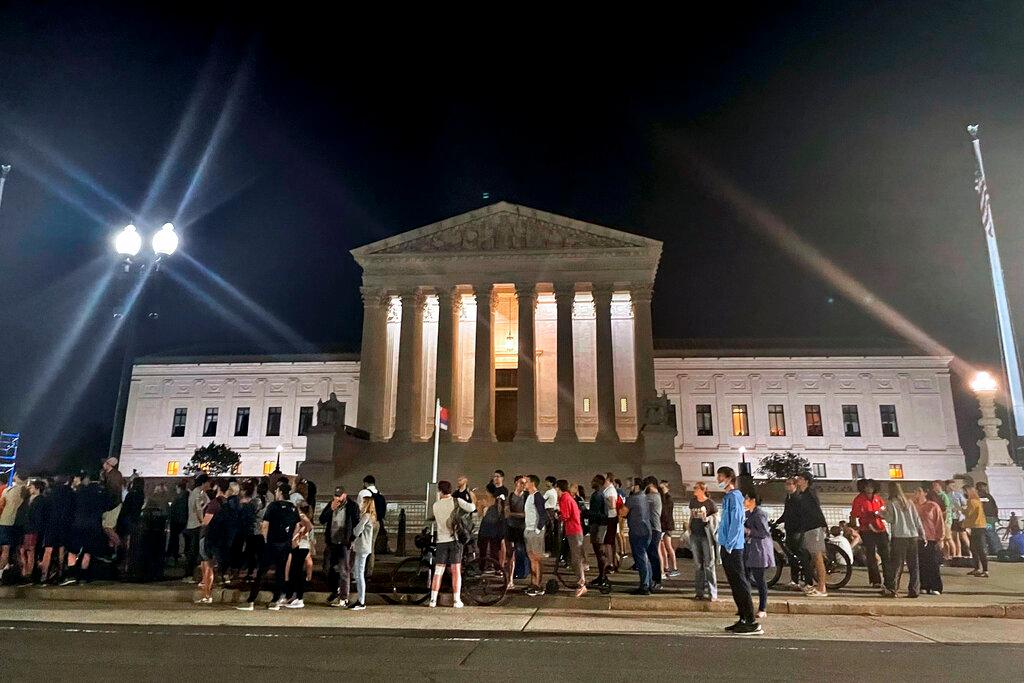 A crowd of people gather outside the Supreme Court, Monday night