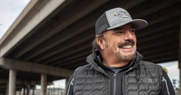 Man with a black vest, sweatshirt and T-shirt with gray hat