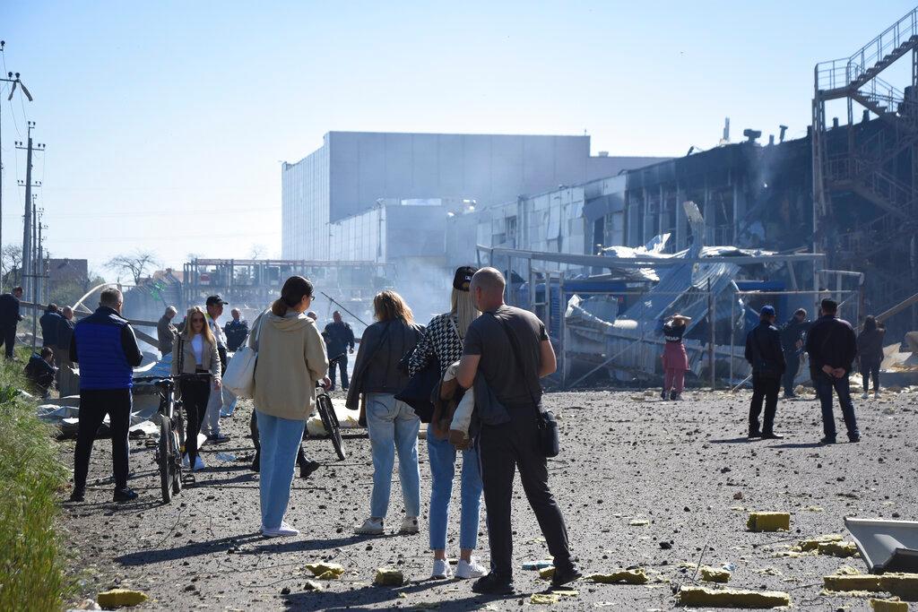 People stand near a destroyed building on the outskirts of Odesa, Ukraine