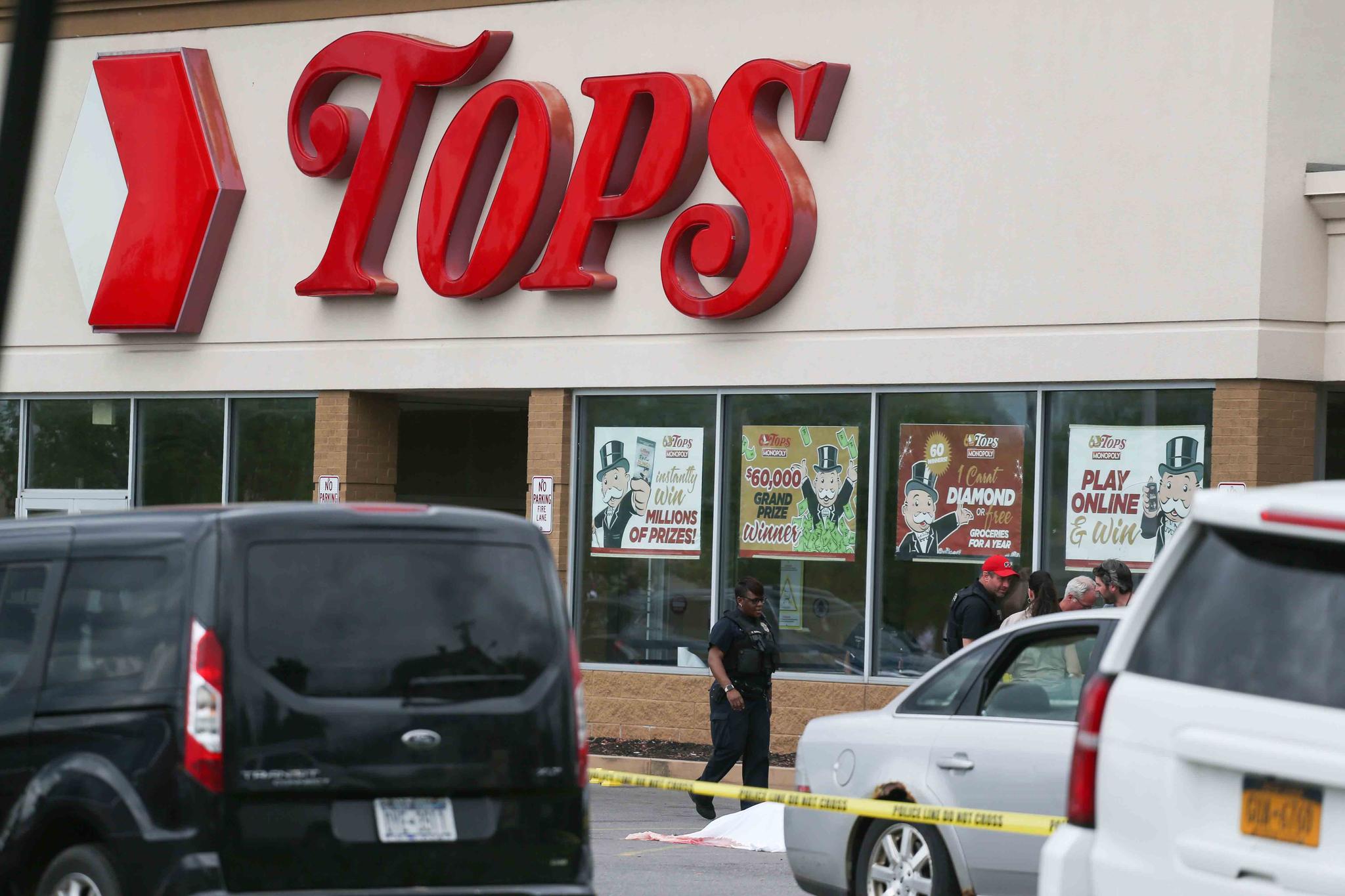 A crowd gathers as police investigate after a shooting at a supermarket on Saturday, May 14, 2022, in Buffalo, N.Y.