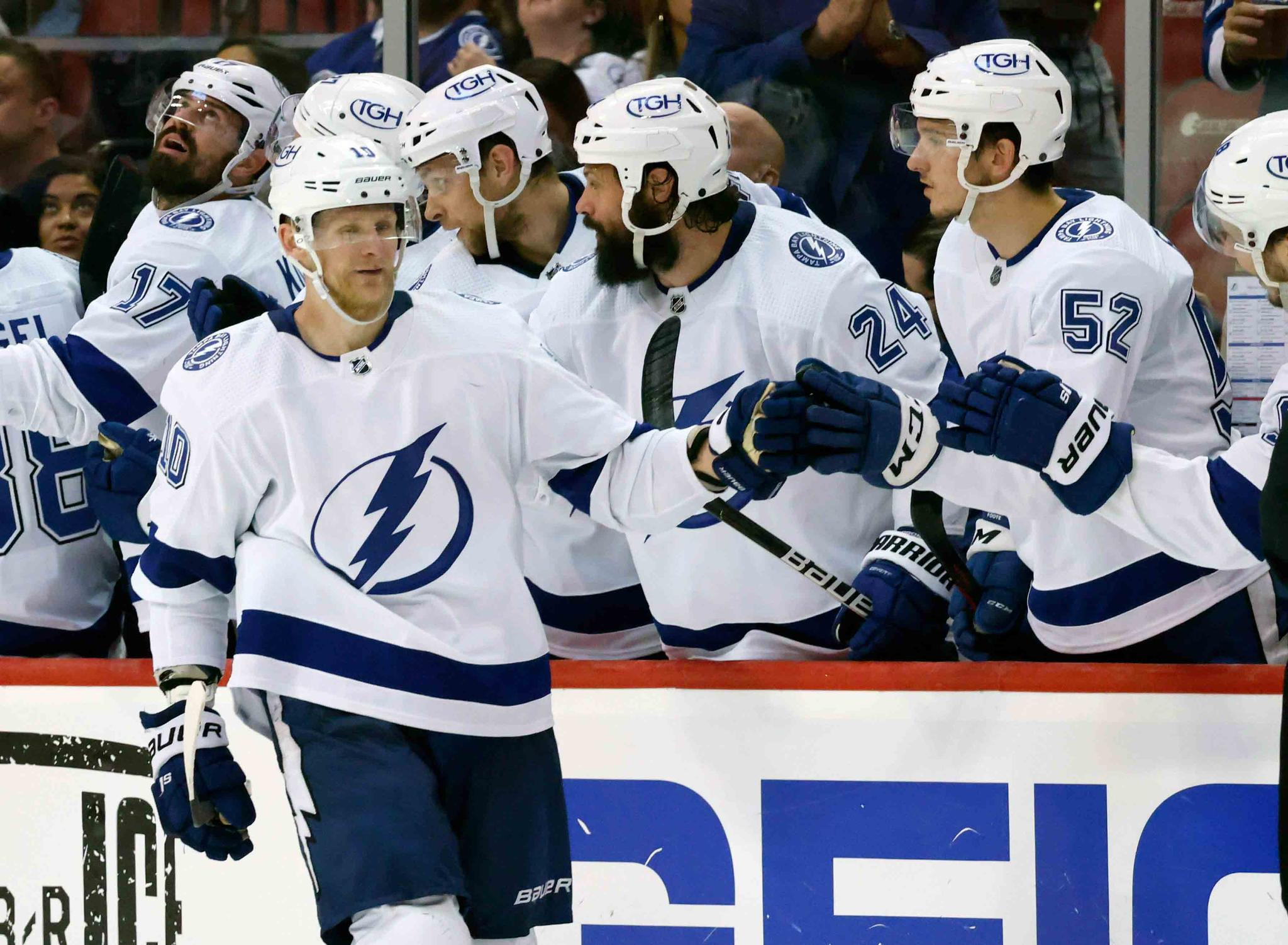 Tampa Bay Lightning right wing Corey Perry (10) celebrates a goal against the Florida Panthers with defenseman Zach Bogosian (24) and defenseman Cal Foote (52) during the second period of Game 1 of an NHL hockey second-round playoff series Tuesday, May 17, 2022, in Sunrise, Fla.