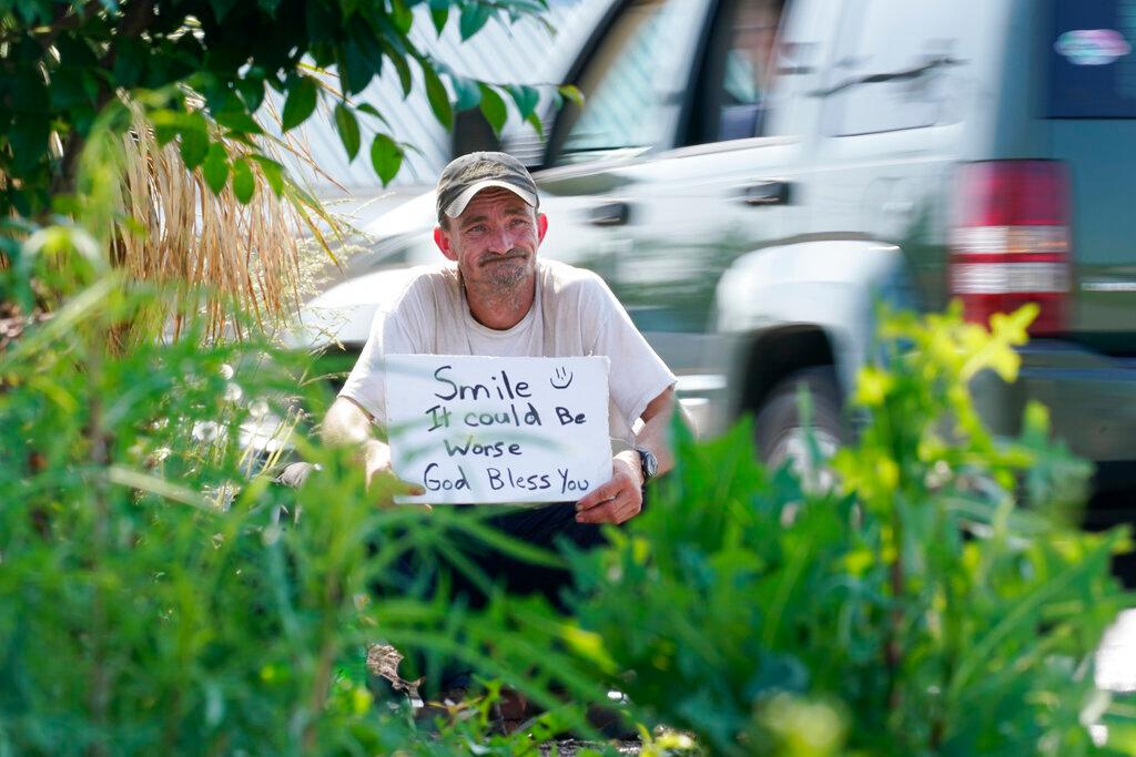 Sean Fuller, who is homeless, panhandles at the entrance to a store in Cookeville, Tenn.