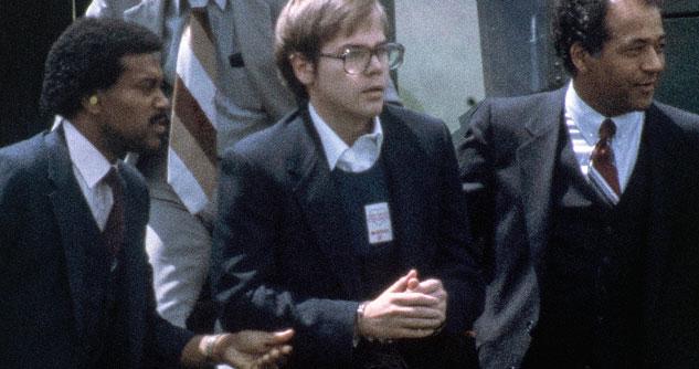 John Hinkley being held by two secret service agents