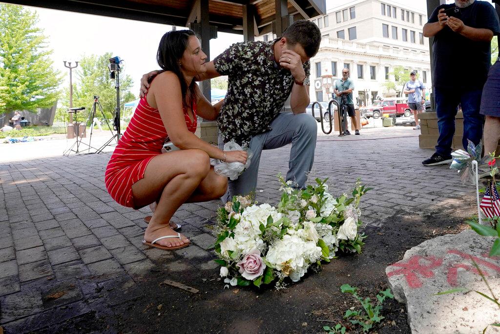 Brooke and Matt Strauss, who were married Sunday, pause after leaving their wedding bouquets in downtown Highland Park, Ill.