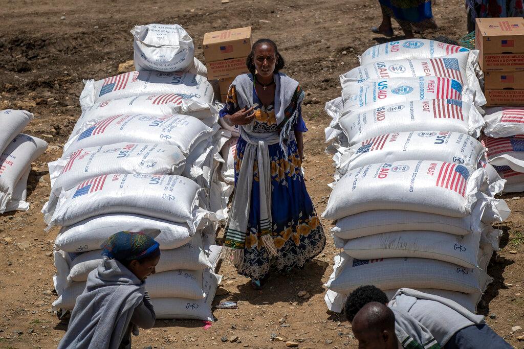 An Ethiopian woman stands by sacks of wheat to be distributed by the Relief Society of Tigray in the town of Agula, in the Tigray region of northern Ethiopia Saturday, May 8, 2021. World hunger rose in 2021 with around 2.3 billion people facing moderate or severe difficulty obtaining food -- and that was before the Ukraine war which has sparked increases in the cost of grain, fertilizer and energy, according to a U.N. report launched Wednesday, July 6, 2022.