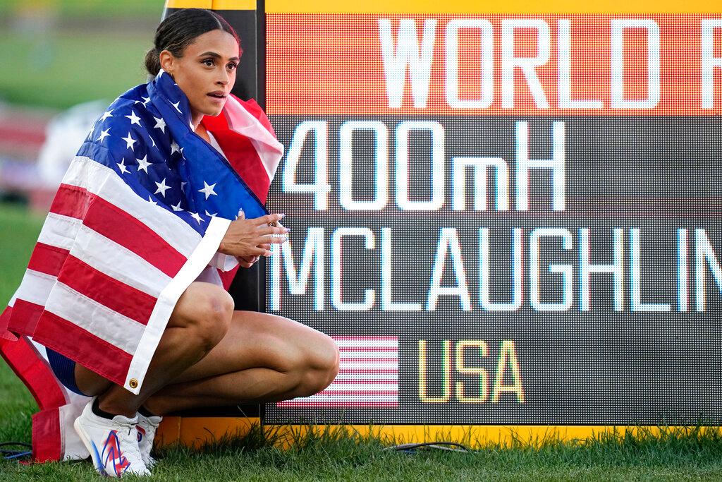 Gold medalist Sydney McLaughlin, of the United States, poses by a sign after winning the final of the women's 400-meter hurdles at the World Athletics Championships