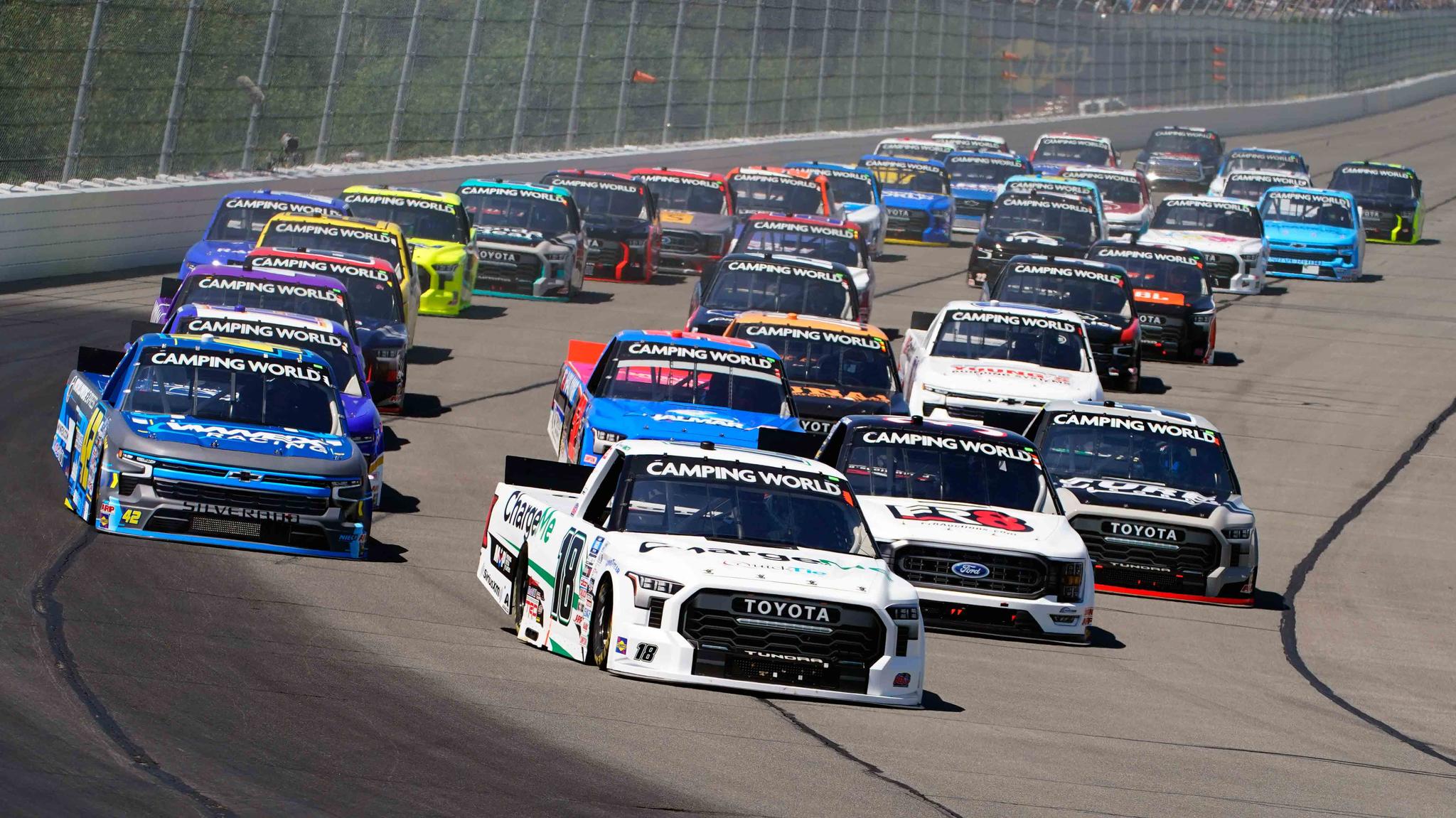 Chandler Smith (18) leads the pack down the front straight on a restart of the NASCAR Truck Series auto race at Pocono Raceway, Saturday, July 23, 2022 in Long Pond, Pa.