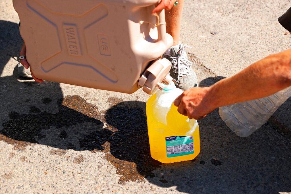 Maggy Johnston, ARCHES outreach coordinator, fills water bottles with Gatorade for houseless people during a heat wave in Salem, Ore.