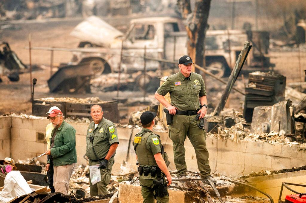 Sheriff's Deputy Johnson stands at a burned home in Klamath National Forest, Calif.