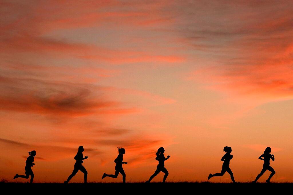 High school students run at sunset